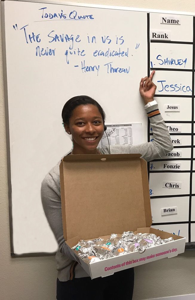 Shirley pointing to her name on a white board