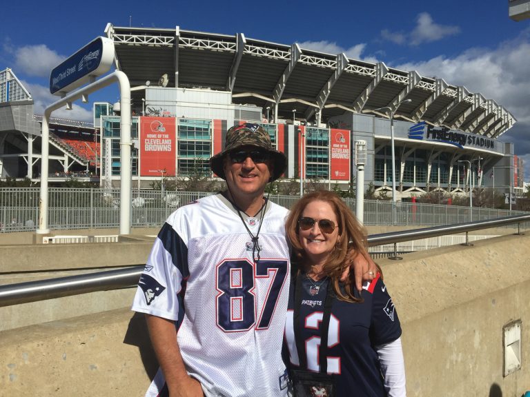 Chris et sa femme en chandails des Patriots au stade